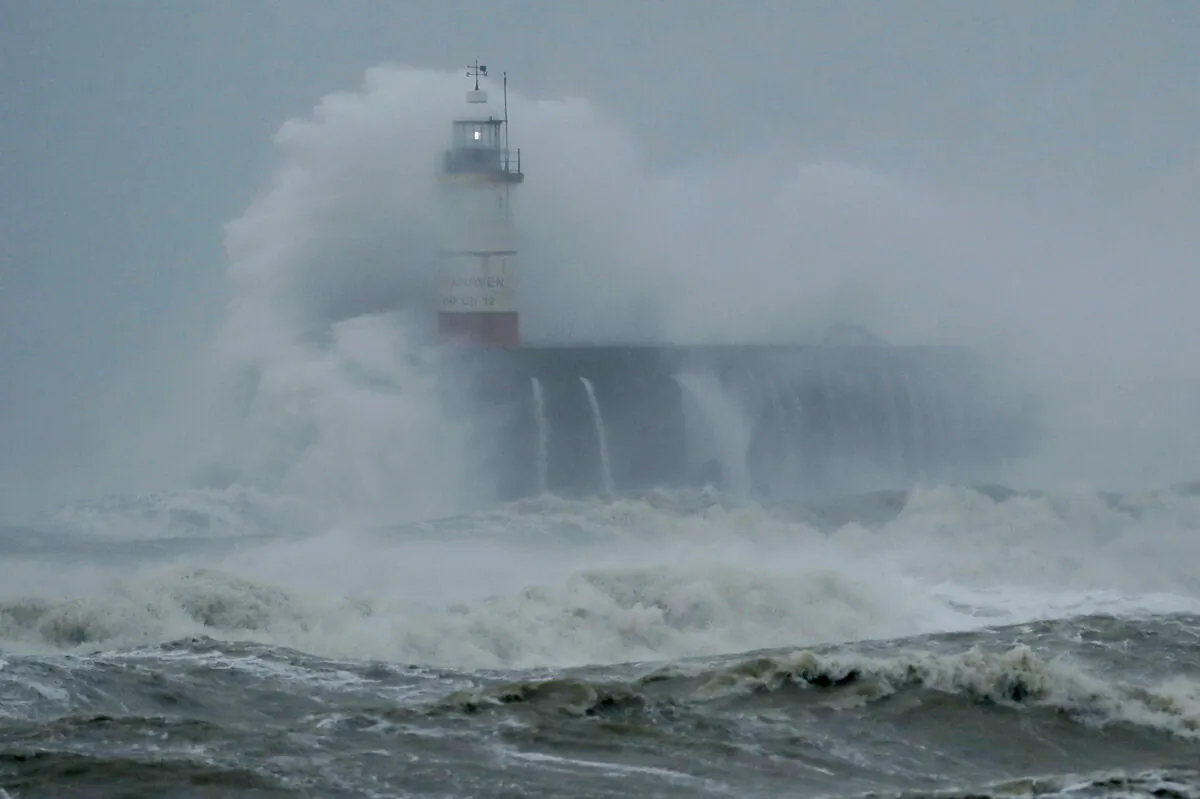 Waves crash over the harbor and a lighthouse, as Storm Ciara hits Newhaven, on the south coast of England, on Sunday, Feb. 9, 2020. (Matt Dunham/AP Photo)