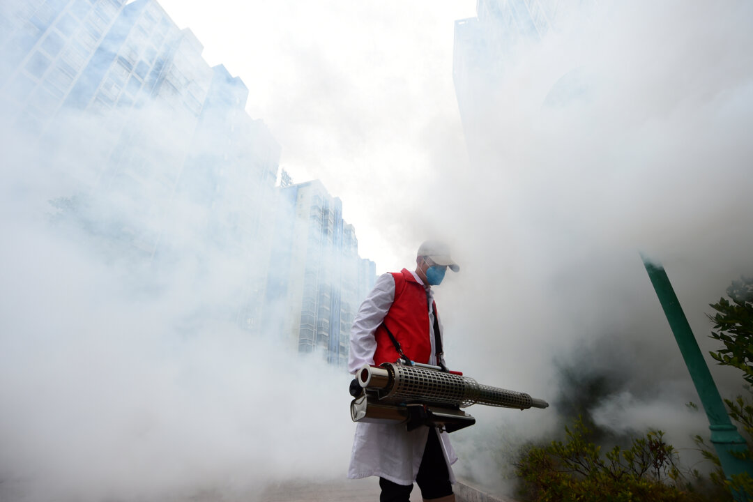 A volunteer disinfects a residential compound to prevent and control the novel coronavirus, in Ganzhou, Jiangxi Province, China, on Feb. 6, 2020. (China Daily via Reuters)