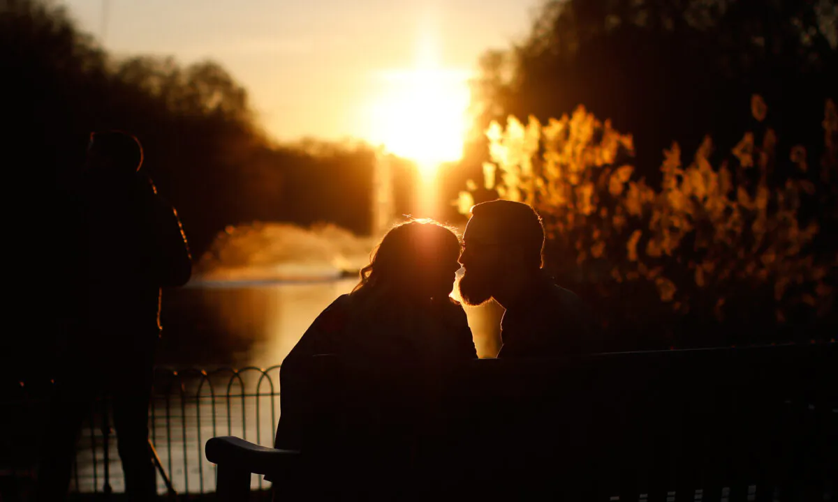 A couple kiss as the sun sets in St. James's Park on Valentine's Day on Feb. 14, 2019. (Tolga Akmen/AFP via Getty Images)