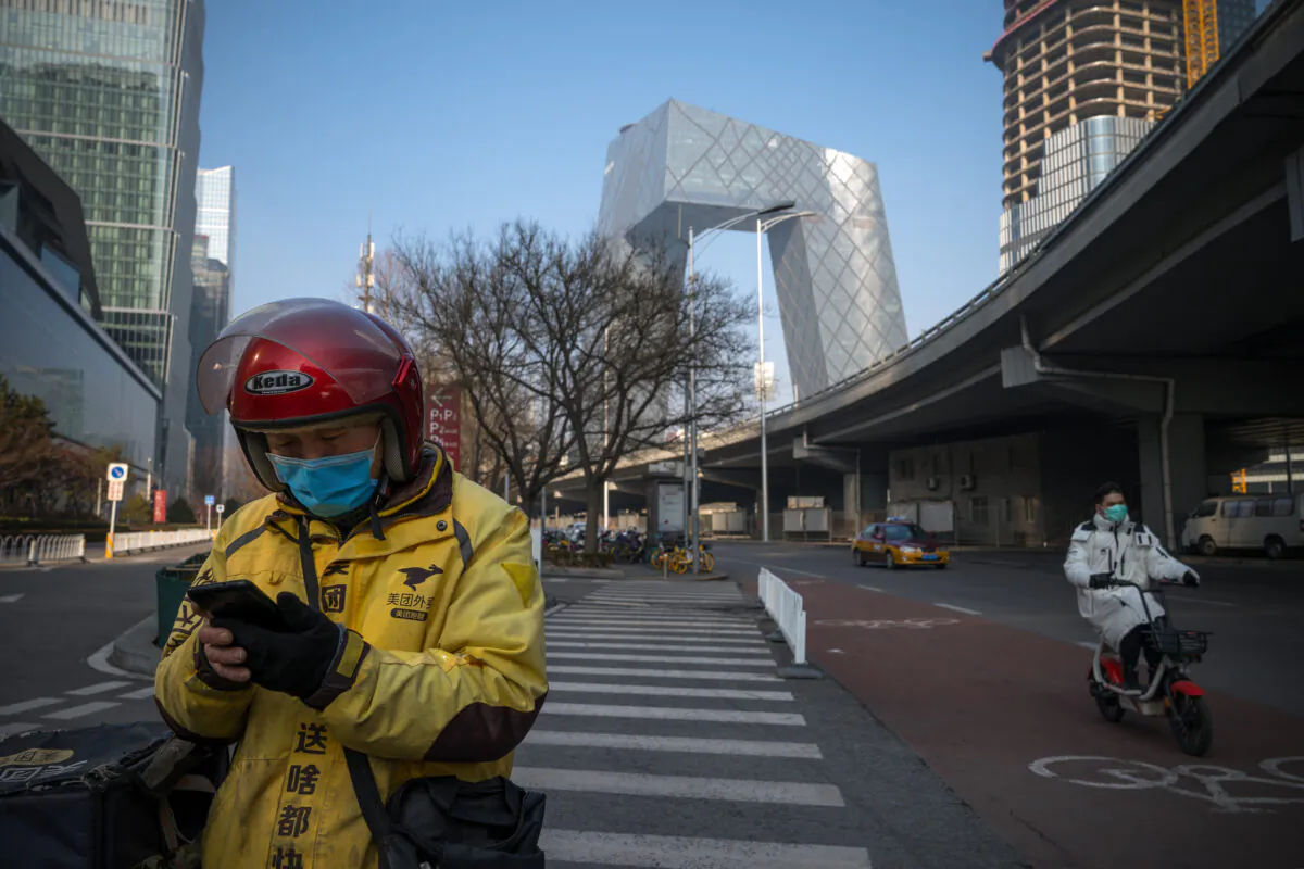 A delivery man uses his phone in the streets of the Central Business District in Beijing on Feb. 10, 2020. (Andrea Verdelli/Getty Images)