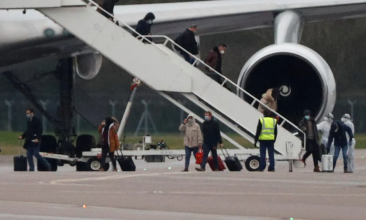 Passengers from China disembark from a plane at RAF Brize Norton near Oxford, United Kingdom, on Feb. 9, 2020. (Peter Nicholls/Reuters/File)