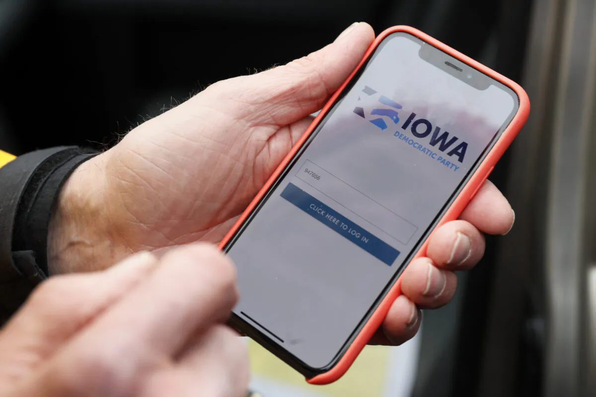 Precinct captain Carl Voss, of Des Moines, Iowa, holds his iPhone that shows the Iowa Democratic Party's caucus reporting app, in Des Moines, Iowa, on Feb. 4, 2020. (Charlie Neibergall/AP Photo)