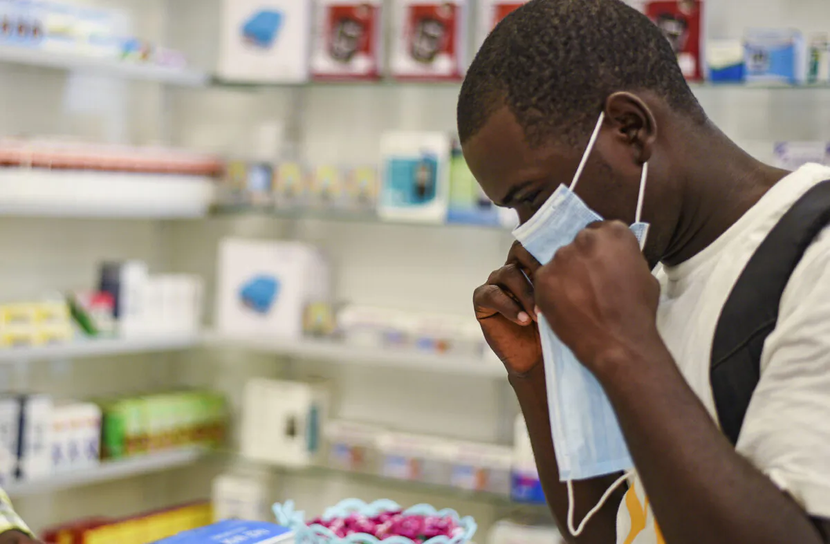 A man tries on a face mask at a pharmacy in Kitwe, Zambia, on Feb. 6, 2020. (Emmanuel Mwiche/AP)