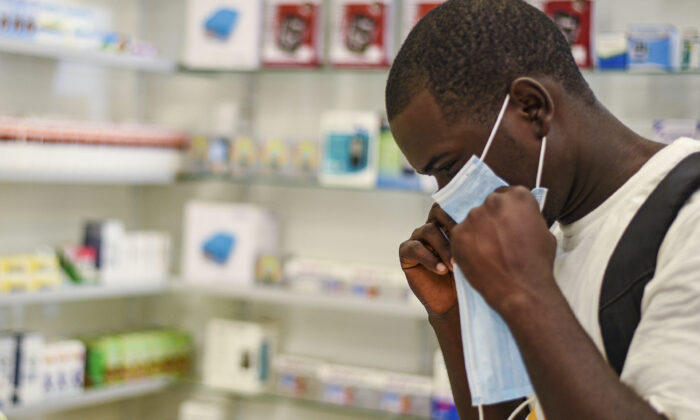 A man tries on a face mask at a pharmacy in Kitwe, Zambia, on Feb. 6, 2020. (Emmanuel Mwiche/AP)
