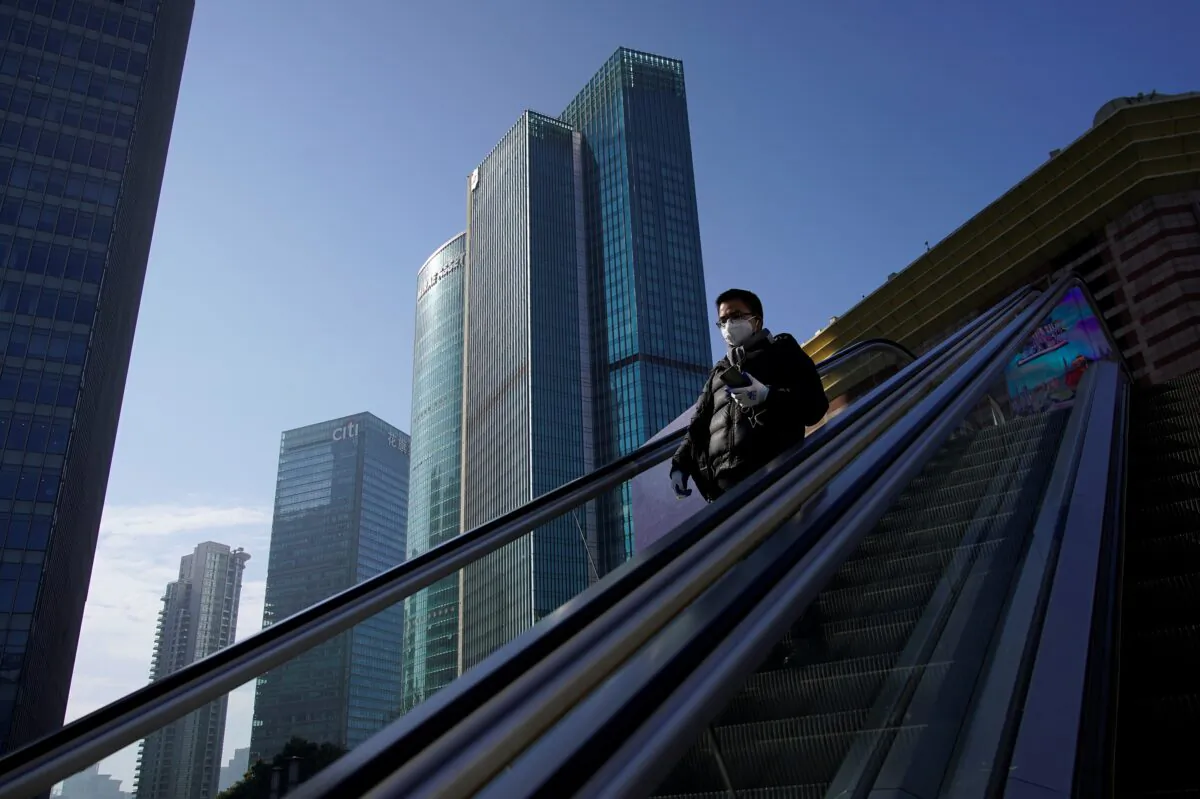 A man wearing a face mask rides an escalator at the Lujiazui financial district in Pudong, Shanghai, China, on Feb. 10, 2020. (Aly Song/Reuters)