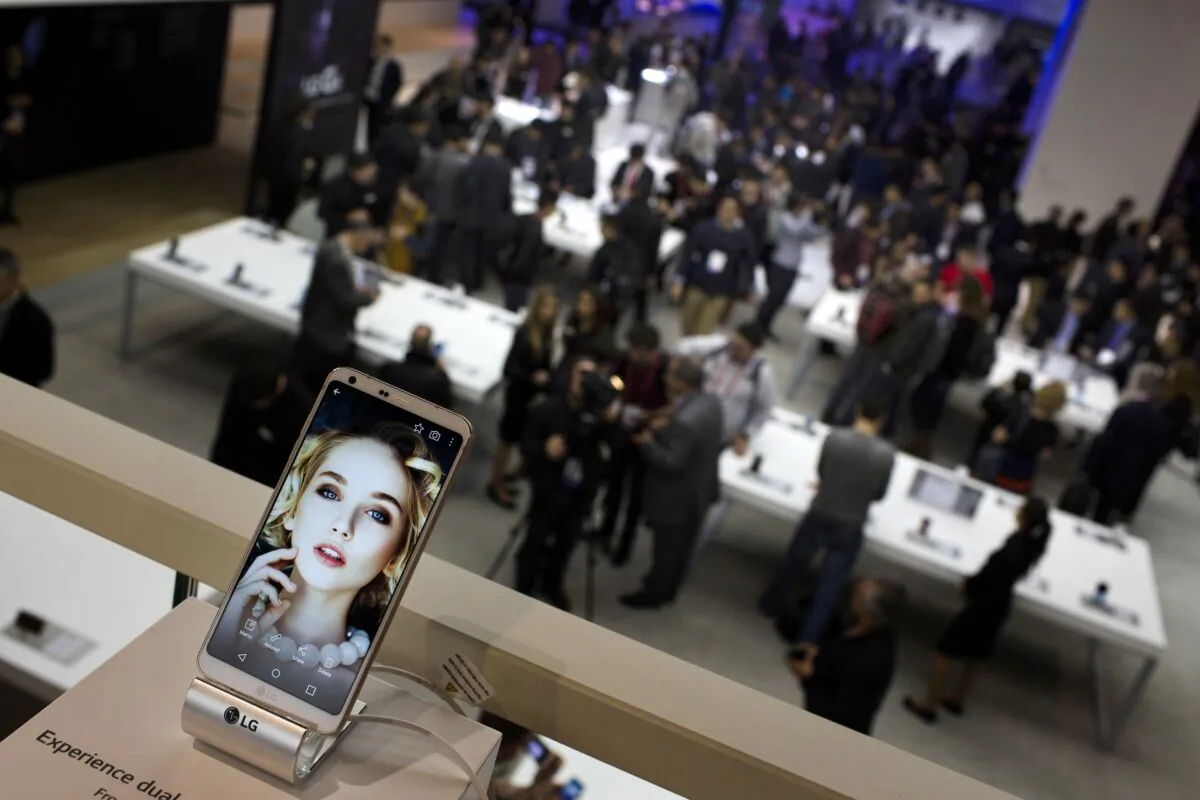 People crowd at the LG stand during the Mobile World Congress wireless show in Barcelona, Spain on Feb. 27, 2017. Sony and Amazon are the latest companies to pull out of a major European technology show over virus fears. (Emilio Morenatti/AP)