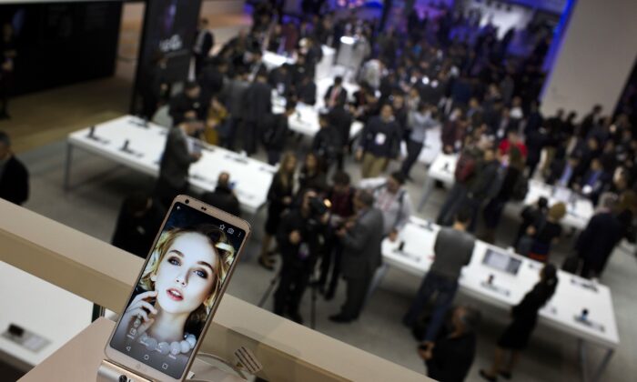 People crowd at the LG stand during the Mobile World Congress wireless show in Barcelona, Spain on Feb. 27, 2017. Sony and Amazon are the latest companies to pull out of a major European technology show over virus fears. (Emilio Morenatti/AP)
