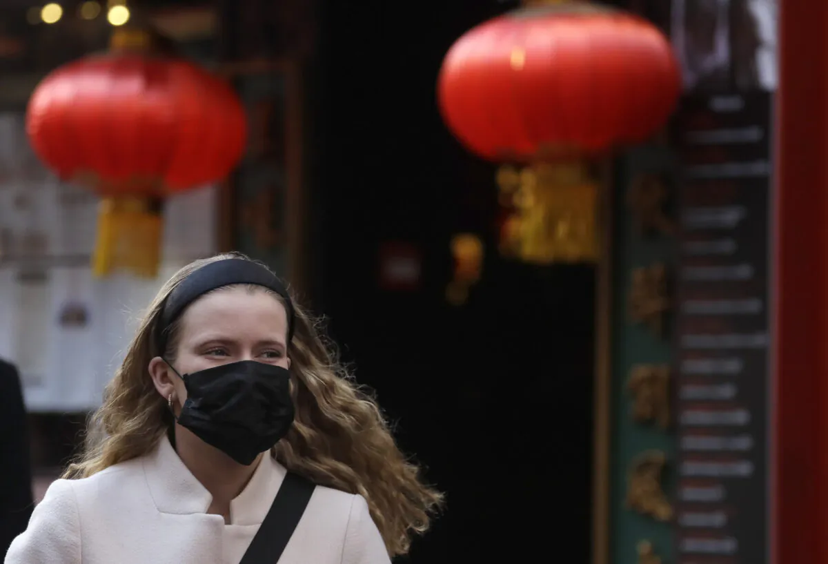 A woman wears a mask as she walks near Chinatown in London on Feb. 7, 2020. (Kirsty Wigglesworth/AP Photo)