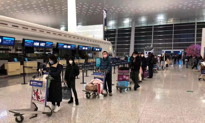 Passengers queue to board a cargo plane, chartered by the U.S. State Department to evacuate Americans and Canadians from China due to the outbreak of novel Coronavirus, at Wuhan Tianhe International Airport in Wuhan, China , on Feb. 7, 2020.  (Courtesy of Edward Wang via Reuters)