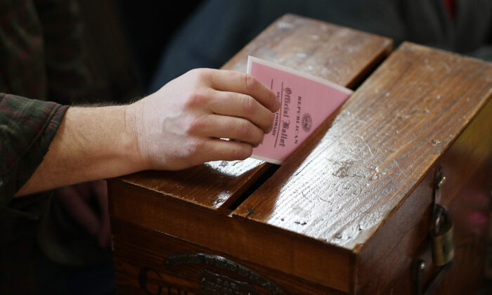 Detail of a voter dropping a voting ballot into the ballot box at the Town Hall in Chichester, N.H., on Feb. 11, 2020. (Joe Raedle/Getty Images)