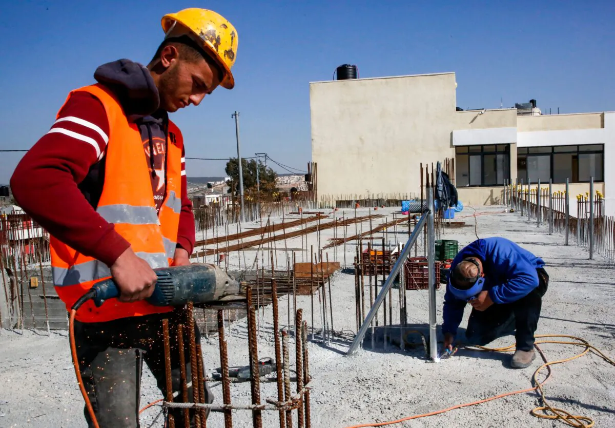 A construction worker saws steel rods at the site of a school that was funded by the U.S Agency for International Development (USAID) in Al-Jabaa, in the West Bank, on Jan. 22, 2019. (HAZEM BADER/AFP via Getty Images)