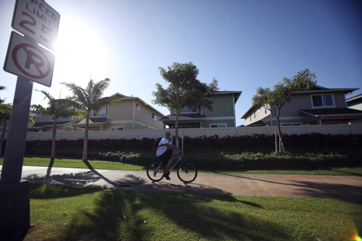 A man cycles past the Trades housing division built by Gentry Homes in Ewa Beach, Hawaii, on March 6, 2013. (Hugh Gentry/Reuters)
