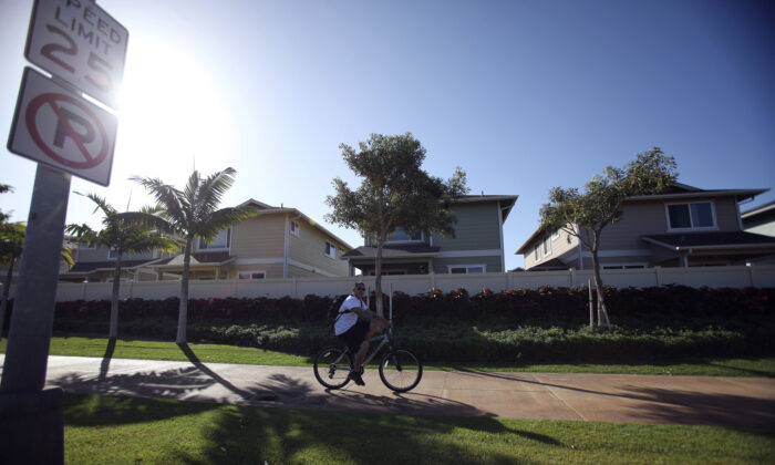 A man cycles past the Trades housing division built by Gentry Homes in Ewa Beach, Hawaii, on March 6, 2013. (Hugh Gentry/Reuters)
