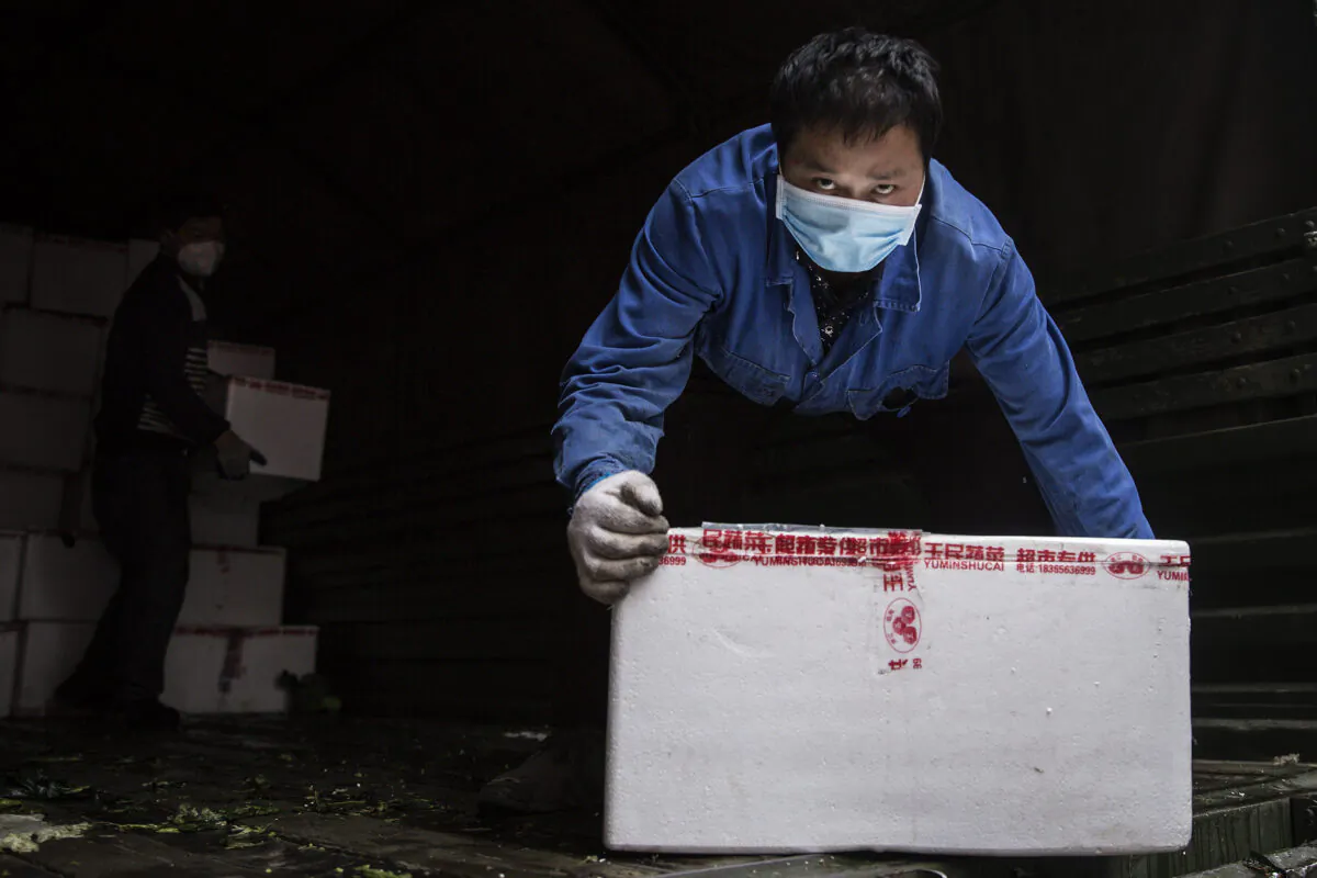 A employee wears a protective mask whilst carrying vegetables from trucks at a hospital in Wuhan, China, on Feb. 10, 2020. (Getty Images)
