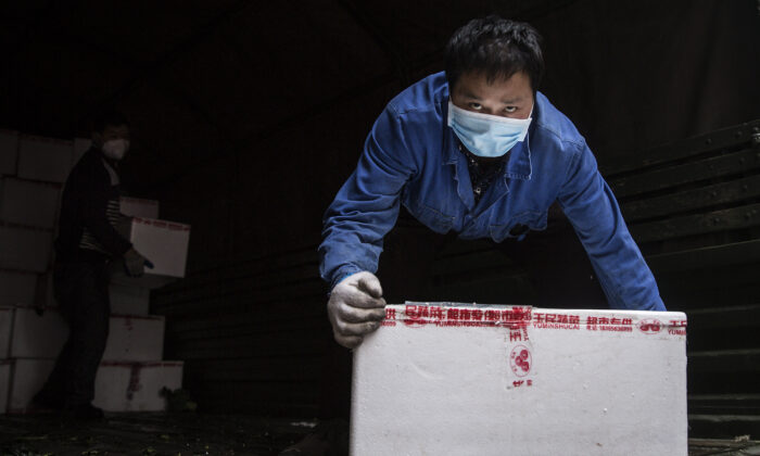 A employee wears a protective mask whilst carrying vegetables from trucks at a hospital in Wuhan, China, on Feb. 10, 2020. (Getty Images)