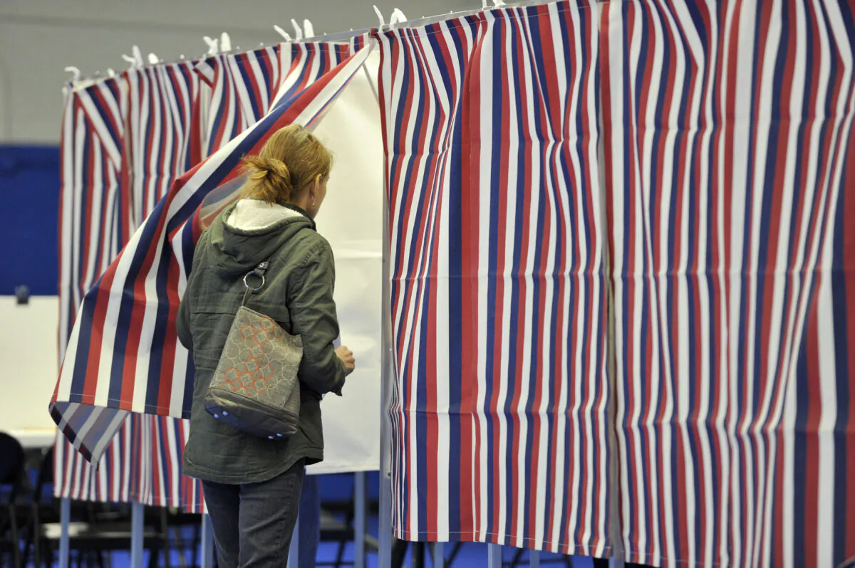 A woman enters a voting booth at the Ward Five Community Center during the New Hampshire primary in Concord, N.H., on Feb. 11, 2020. (Joseph Prezioso/AFP via Getty Images)