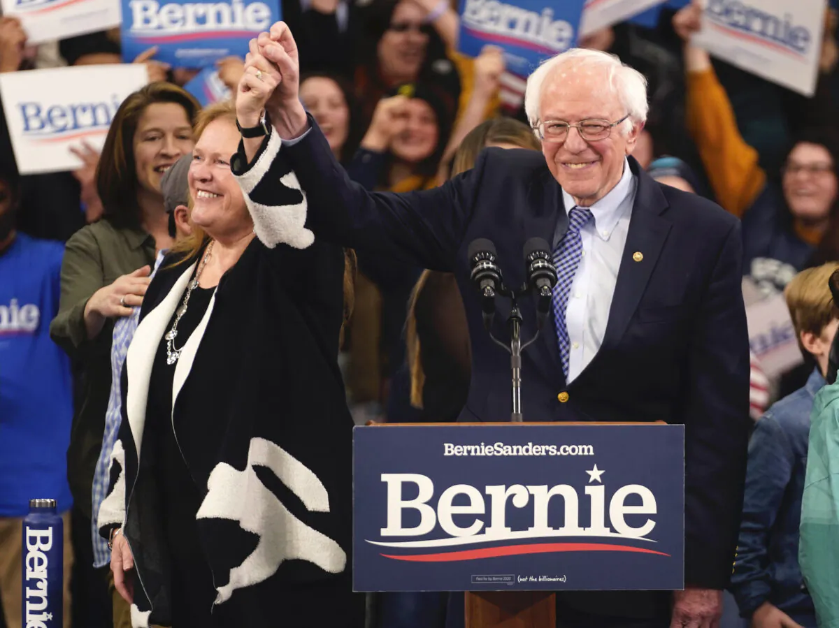 Democratic U.S. presidential candidate Sen. Bernie Sanders (I-Vt.) is accompanied by his wife Jane O’Meara Sanders as he arrives to speak at his New Hampshire primary night rally in Manchester, New Hampshire, on Feb. 11, 2020. (Rick Wilking/Reuters)
