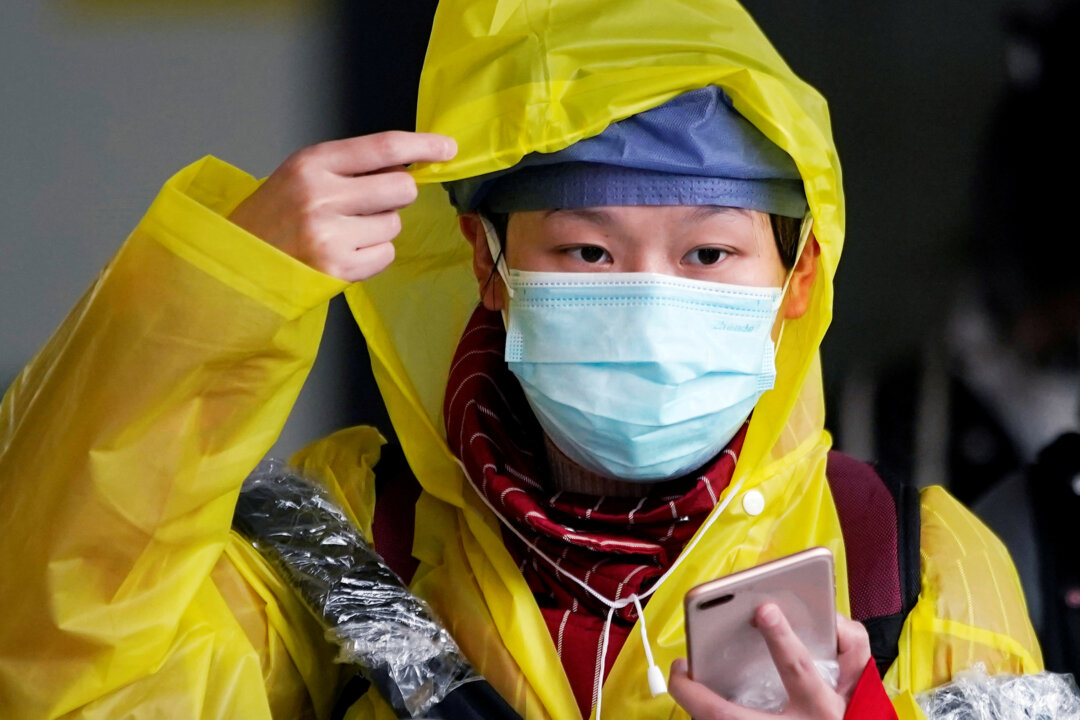 A passenger wearing a mask walks outside the Shanghai railway station in Shanghai, China, as the country is hit by an outbreak of the new coronavirus, on Feb. 8, 2020. (Aly Song/Reuters)