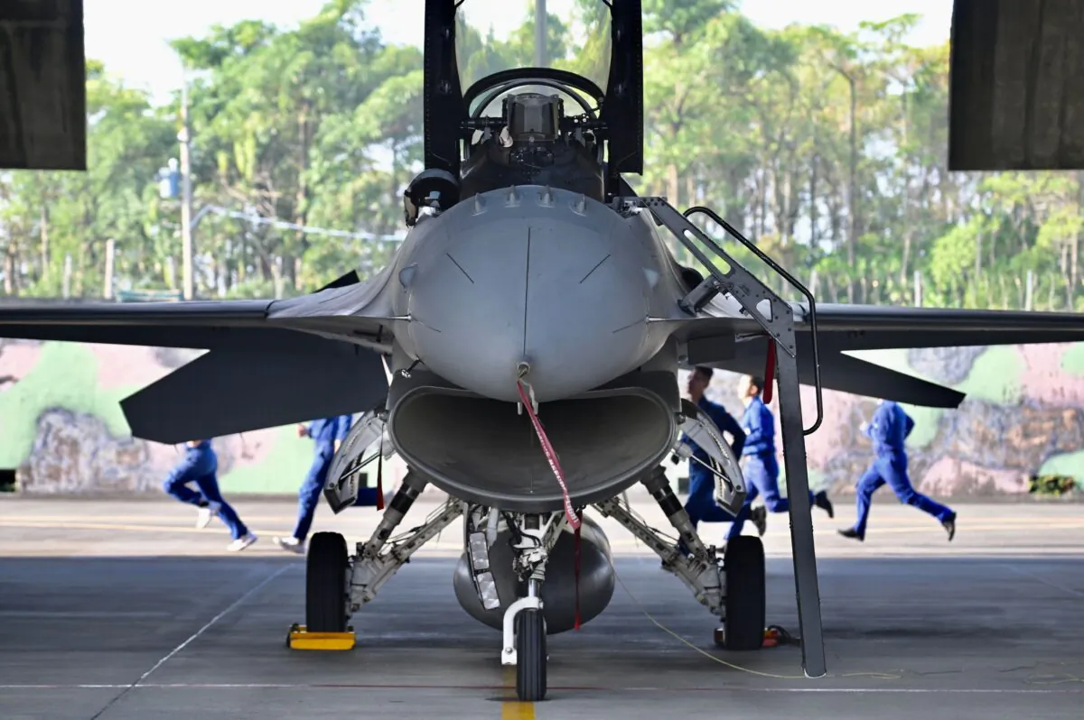 A group of Taiwan Air Force technicians run behind a US-made F-16V fighter jet during an exercise at a military base in Chiayi, southern Taiwan on Jan. 15, 2020. (Sam Yeh/AFP via Getty Images)