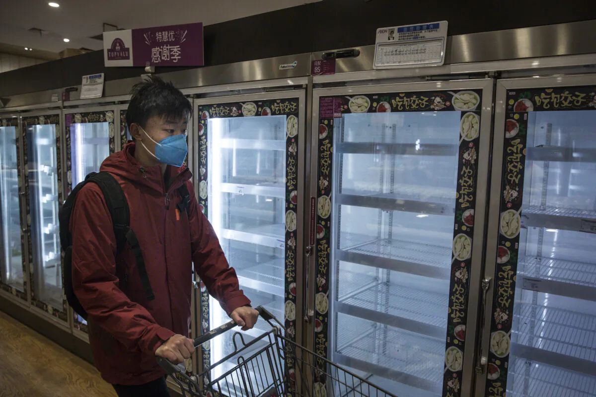 A resident passes by empty shelves in the supermarket in Wuhan, China on Feb. 12, 2020. (Getty Images)