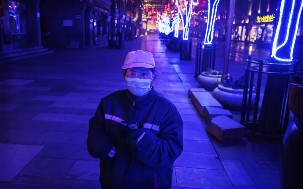 A Chinese worker stands in a nearly empty and shuttered commercial street in Beijing, China on Feb. 12, 2020. (Kevin Frayer/Getty Images)