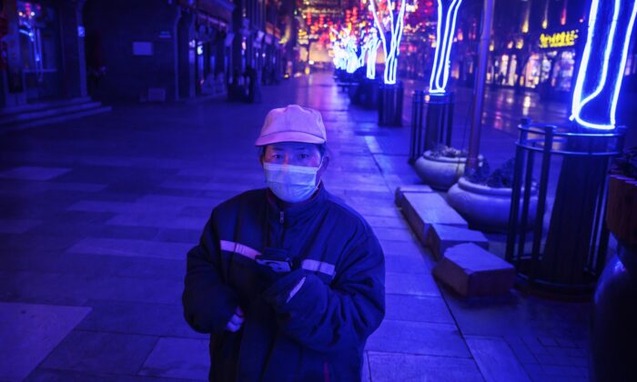 A Chinese worker stands in a nearly empty and shuttered commercial street in Beijing, China on Feb. 12, 2020. (Kevin Frayer/Getty Images)