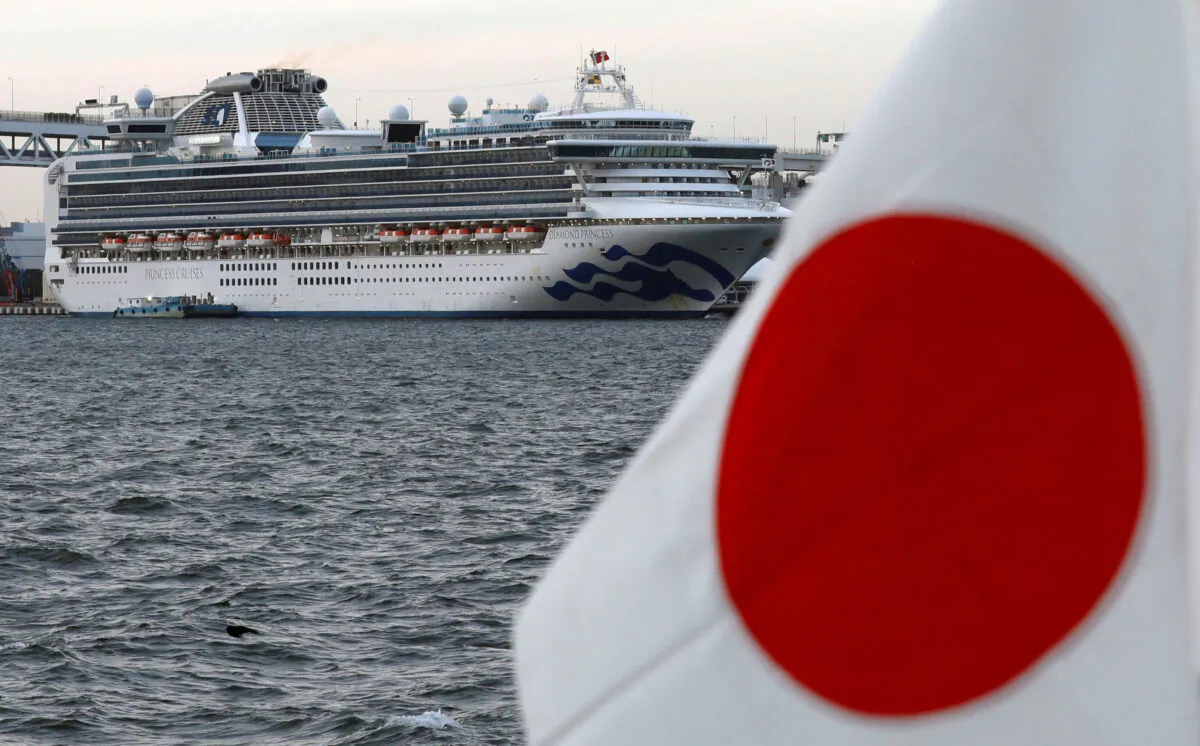The cruise ship Diamond Princess is pictured beside a Japanese flag as it lies at anchor while workers and officers prepare to transfer passengers who tested positive for coronavirus, at Daikoku Pier Cruise Terminal in Yokohama, Japan, on Feb. 12, 2020. (Kim Kyung-Hoon/ Reuters/File Photo)