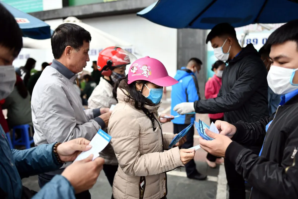 Vietnamese residents queue to receive free protective facemasks at a make-shift distribution centre amid concerns of the novel coronavirus outbreak, in Hanoi on Feb. 8, 2020. (Photo by Manan Vatsyayana/AFP/Getty Images)
