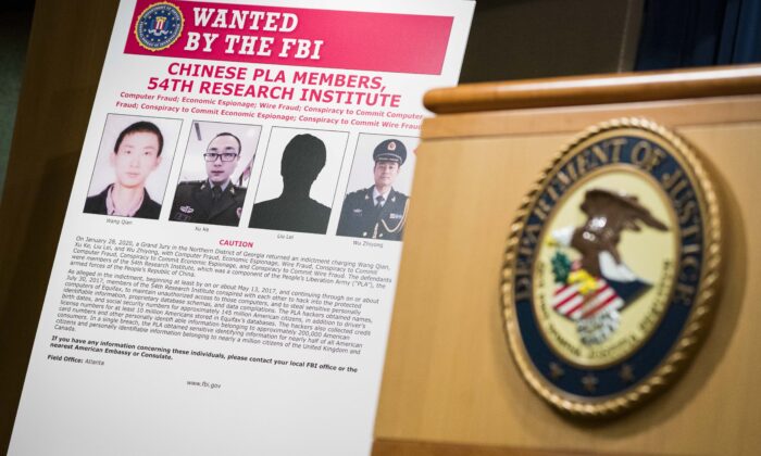 Signs that depict the four members of China's military indicted on charges of hacking into Equifax Inc. and stealing data from millions of Americans are seen shortly after Attorney General William Barr held a press conference at the Department of Justice in Washington on Feb. 10, 2020. (Sarah Silbiger/Getty Images)