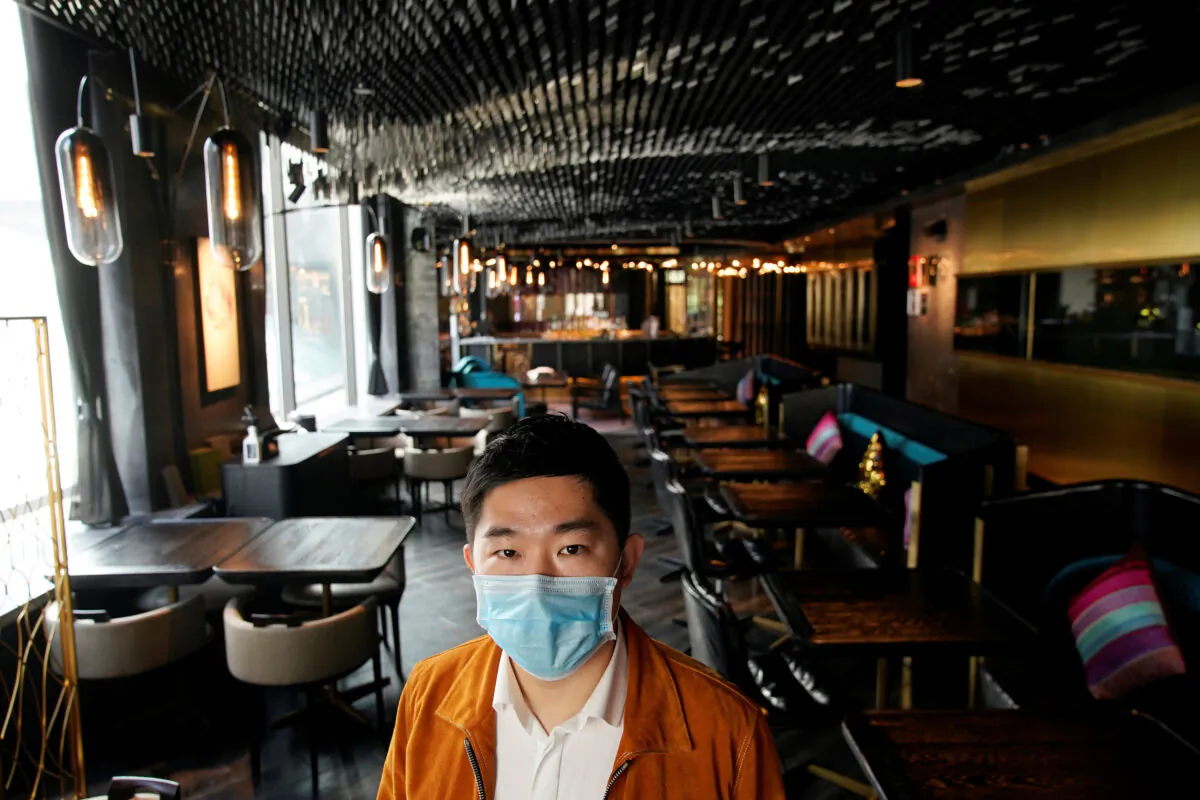 Bill Hu, founder and CEO of seul & SEUL restaurant, wears a mask and poses for pictures in downtown Shanghai, China, as the country is hit by an outbreak of a new coronavirus, on Feb. 12, 2020. (/Aly Song/Reuters)