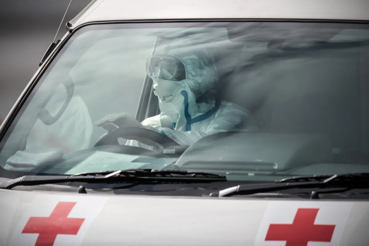 An emergency worker in protective clothing drives an ambulance carrying a person diagnosed with COVID-19 in Yokohama, Japan, on Feb. 13, 2020. (Carl Court/Getty Images)
