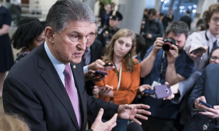 Sen. Joe Manchin (D-W.Va.) speaks to the press near the Senate subway following a vote in the Senate impeachment trial that acquitted President Donald Trump of all charges in Washington on Feb. 5, 2020. (Sarah Silbiger/Getty Images)