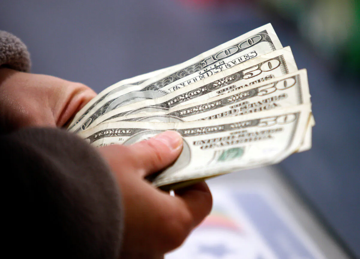 File photo showing a customer counting money at the register of a store in Manchester, N.H., on Nov. 22, 2012. (Jessica Rinaldi/Reuters)