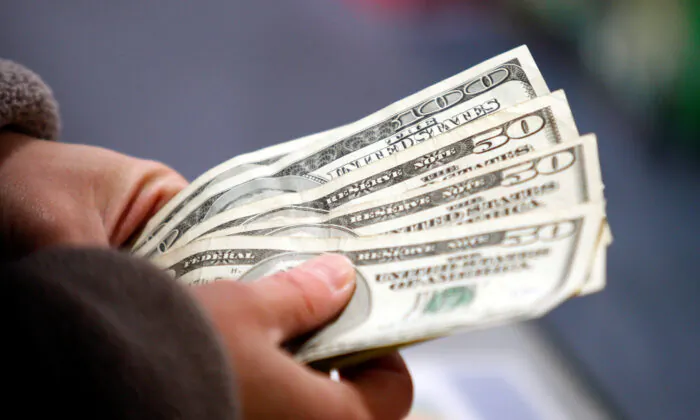 File photo showing a customer counting money at the register of a store in Manchester, N.H., on Nov. 22, 2012. (Jessica Rinaldi/Reuters)