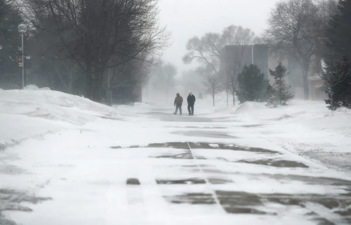A pair of pedestrians make their way across campus at Northern State University in South Dakota on Feb. 12, 2020. (American News via AP/John Davis)