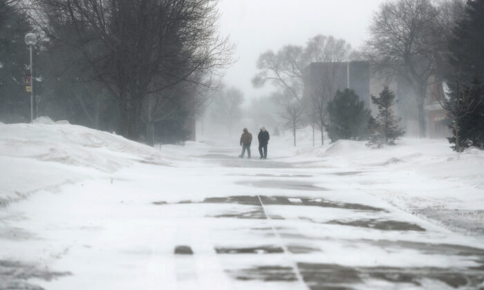 A pair of pedestrians make their way across campus at Northern State University in South Dakota on Feb. 12, 2020. (American News via AP/John Davis)