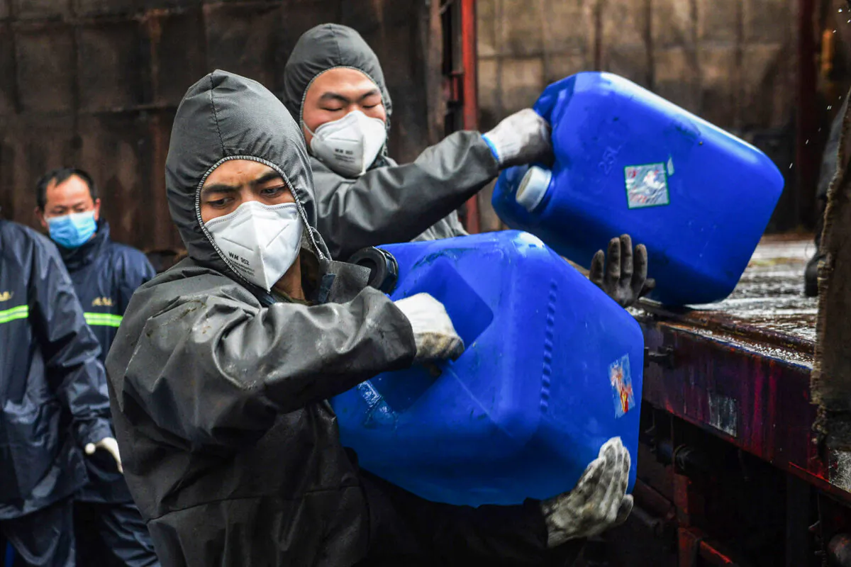 Chinese paramilitary police officers wearing protective gears transfer pails of disinfectant in Yunmeng County outside Xiaogan City in China's central Hubei province on Feb. 12, 2020. (STR/AFP via Getty Images)