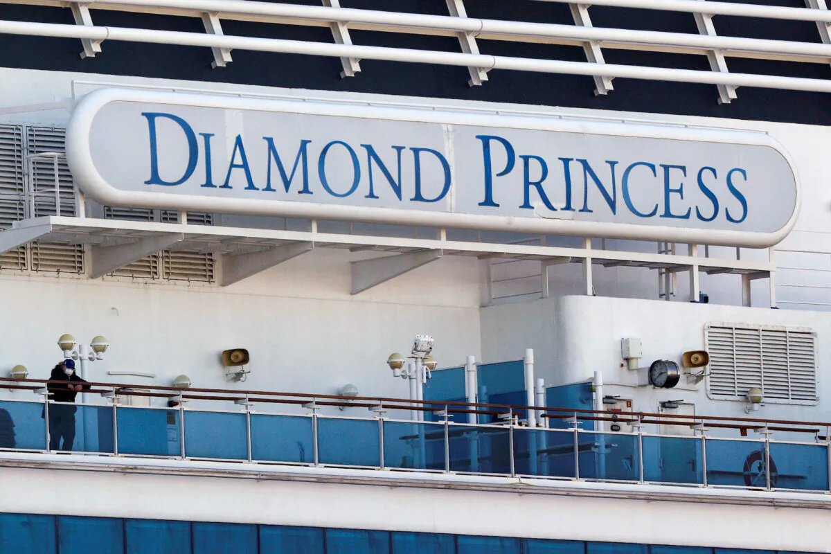 A passenger wearing a mask stands on the deck of the cruise ship Diamond Princess, as the vessel's passengers continue to be tested for coronavirus, at Daikoku Pier Cruise Terminal in Yokohama, south of Tokyo, Japan, on Feb. 13, 2020. (Kim Kyung-Hoon/Reuters)