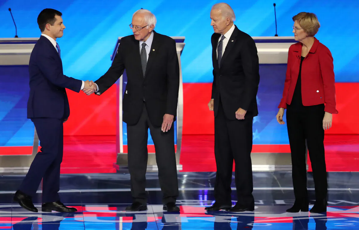 Democratic presidential candidates former South Bend, Indiana, Mayor Pete Buttigieg and Sen. Bernie Sanders (I-VT) shake hands as former Vice President Joe Biden and Sen. Elizabeth Warren (D-MA) look on prior to the start of the Democratic presidential primary debate in the Sullivan Arena at St. Anselm College on Feb. 07, 2020 in Manchester, New Hampshire. (Joe Raedle/Getty Images)