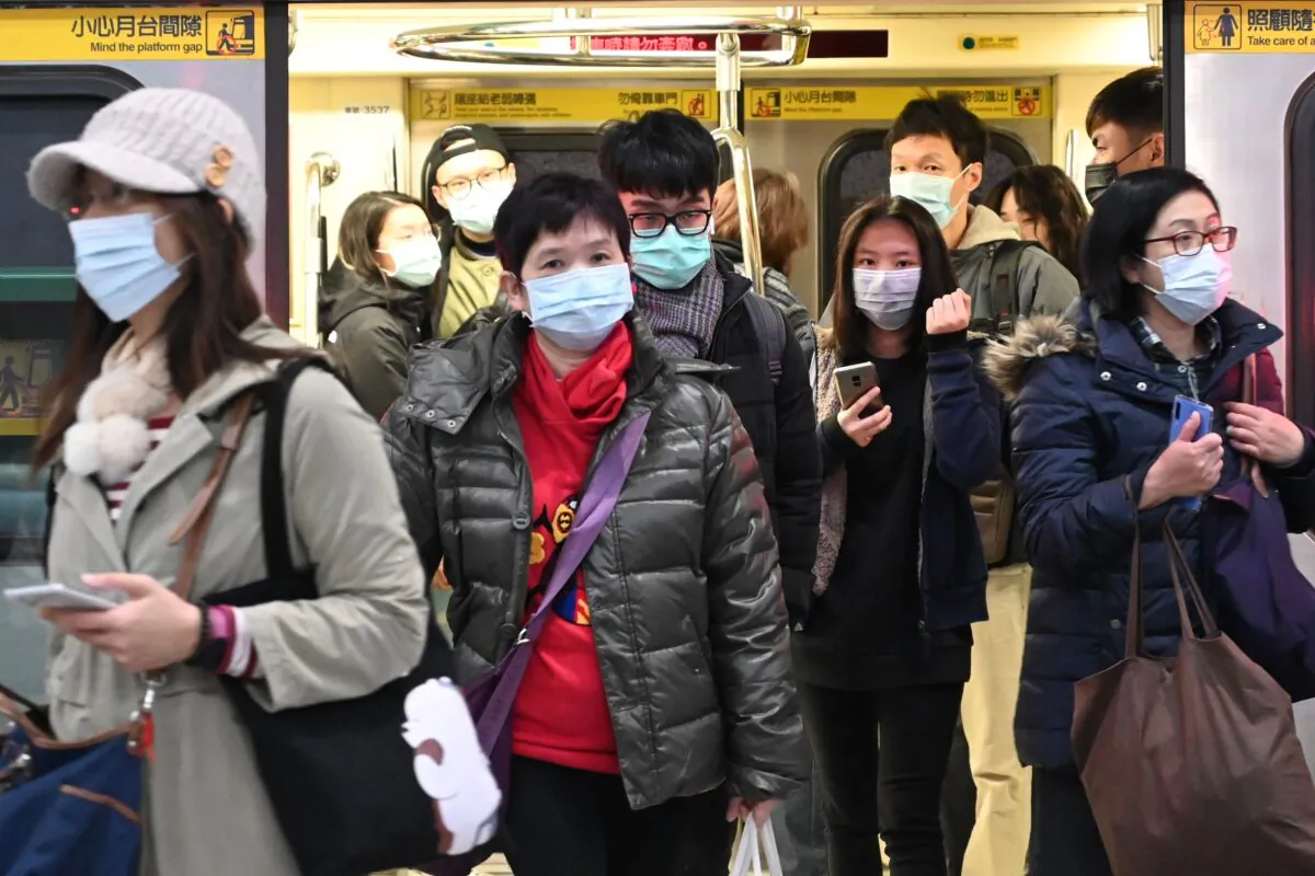 Mask-clad commuters get off a train at a Mass Rapid Transit (MRT) stop in Taipei, Taiwan, on Jan. 30, 2020. (Sam Yeh/AFP via Getty Images)