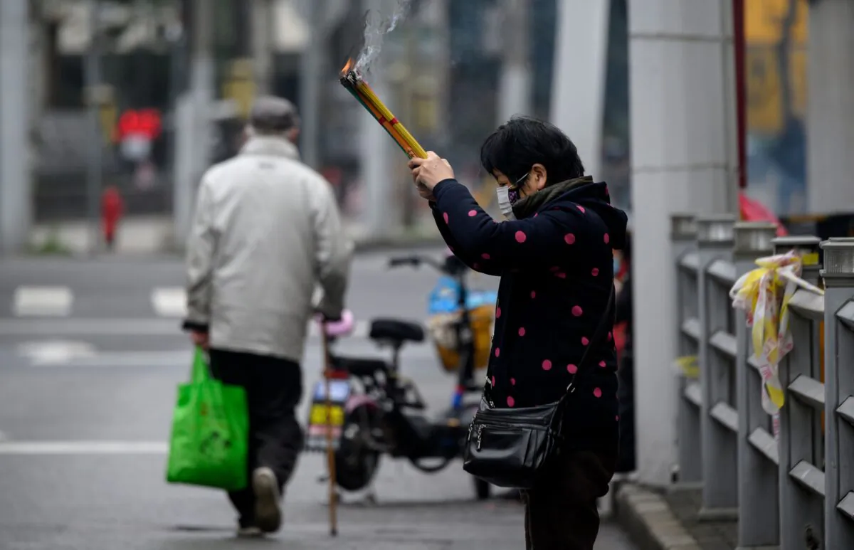 A woman prays outside the closed Jade Buddha Temple in Shanghai on Feb. 14, 2020. (NOEL CELIS/AFP via Getty Images)