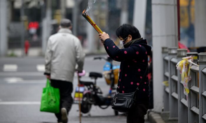 A woman prays outside the closed Jade Buddha Temple in Shanghai on Feb. 14, 2020. (NOEL CELIS/AFP via Getty Images)