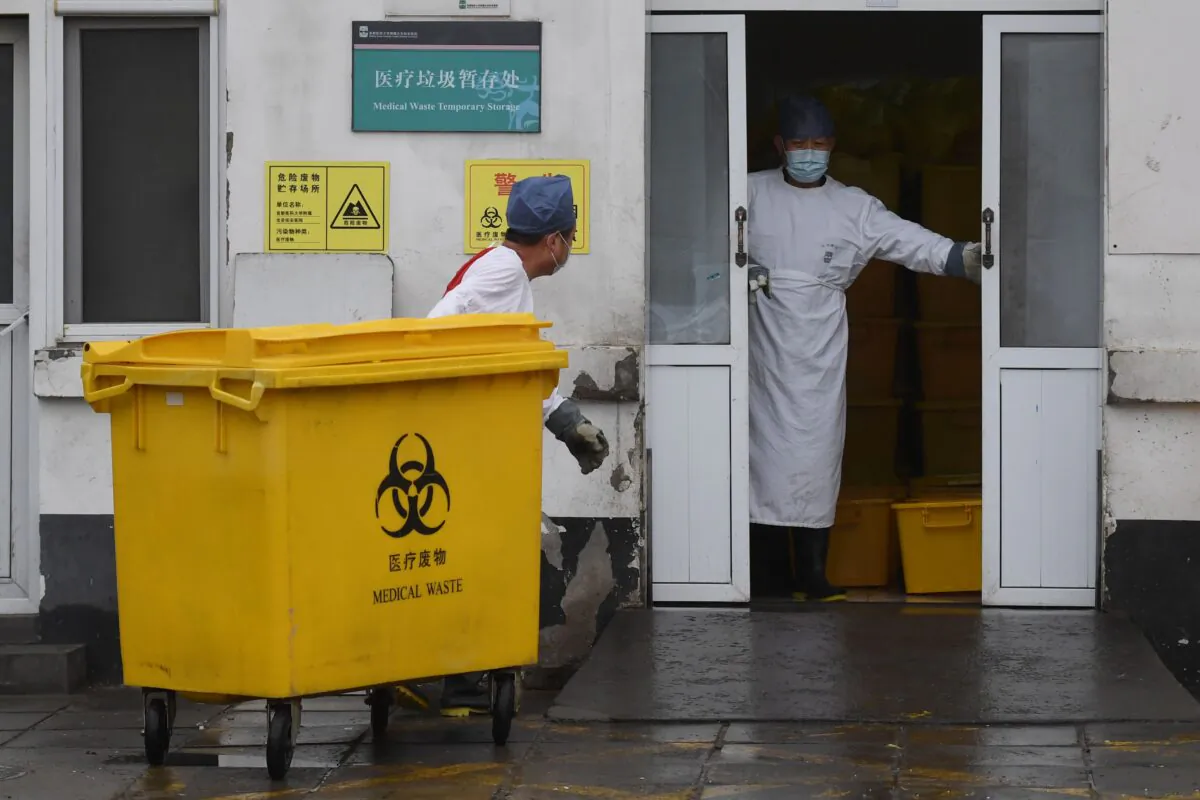 A worker carts a bin loaded with medical waste to a storage facility at the You’an Hospital in Beijing, China, on Feb. 14, 2020. (Greg Baker/AFP via Getty Images)