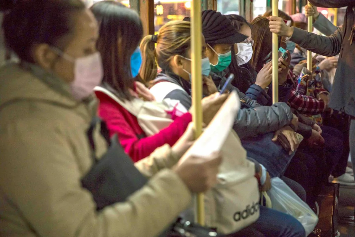 People wearing protective face masks commute on a tram in Hong Kong on Feb. 9, 2020. (Dale De La Rey/AFP via Getty Images)