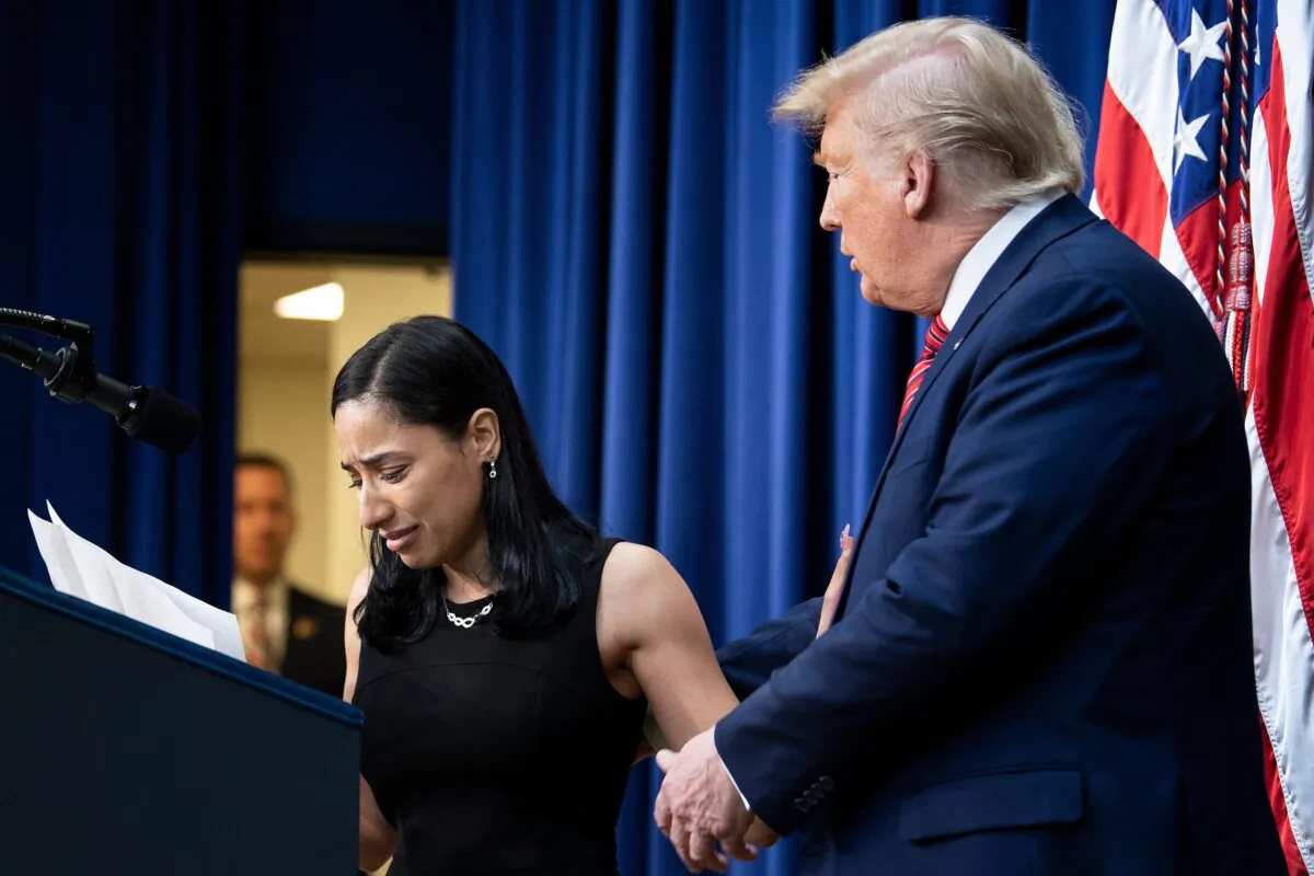 President Donald Trump reaches for Daria Ortiz, granddaughter of murder victim Maria Fuentes, as she speaks to members of the National Border Patrol Council (NBPC) in the South Court Auditorium of the Eisenhower Executive Office Building at the White House in Washington on Feb. 14, 2020. (Brendan Smialowski/AFP via Getty Images)