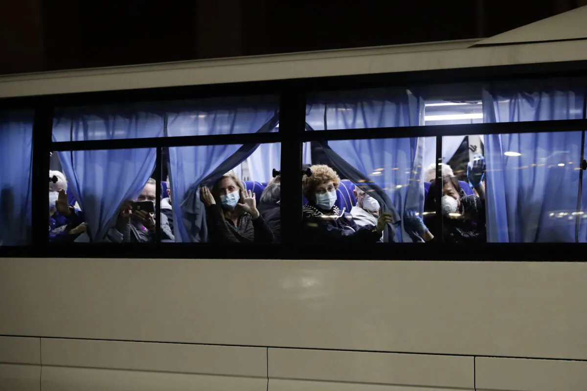 Buses carrying passengers from the quarantined Diamond Princess cruise ship leave a port in Yokohama, near Tokyo, Monday, Feb. 17, 2020. A group of Americans are cutting short a 14-day quarantine on the Diamond Princess cruise ship in the port of Yokohama, near Tokyo, to be whisked back to America. But they will have to spend another quarantine period at a U.S. military facility to make sure they don't have the new virus that's been sweeping across Asia. (AP Photo/Jae C. Hong)