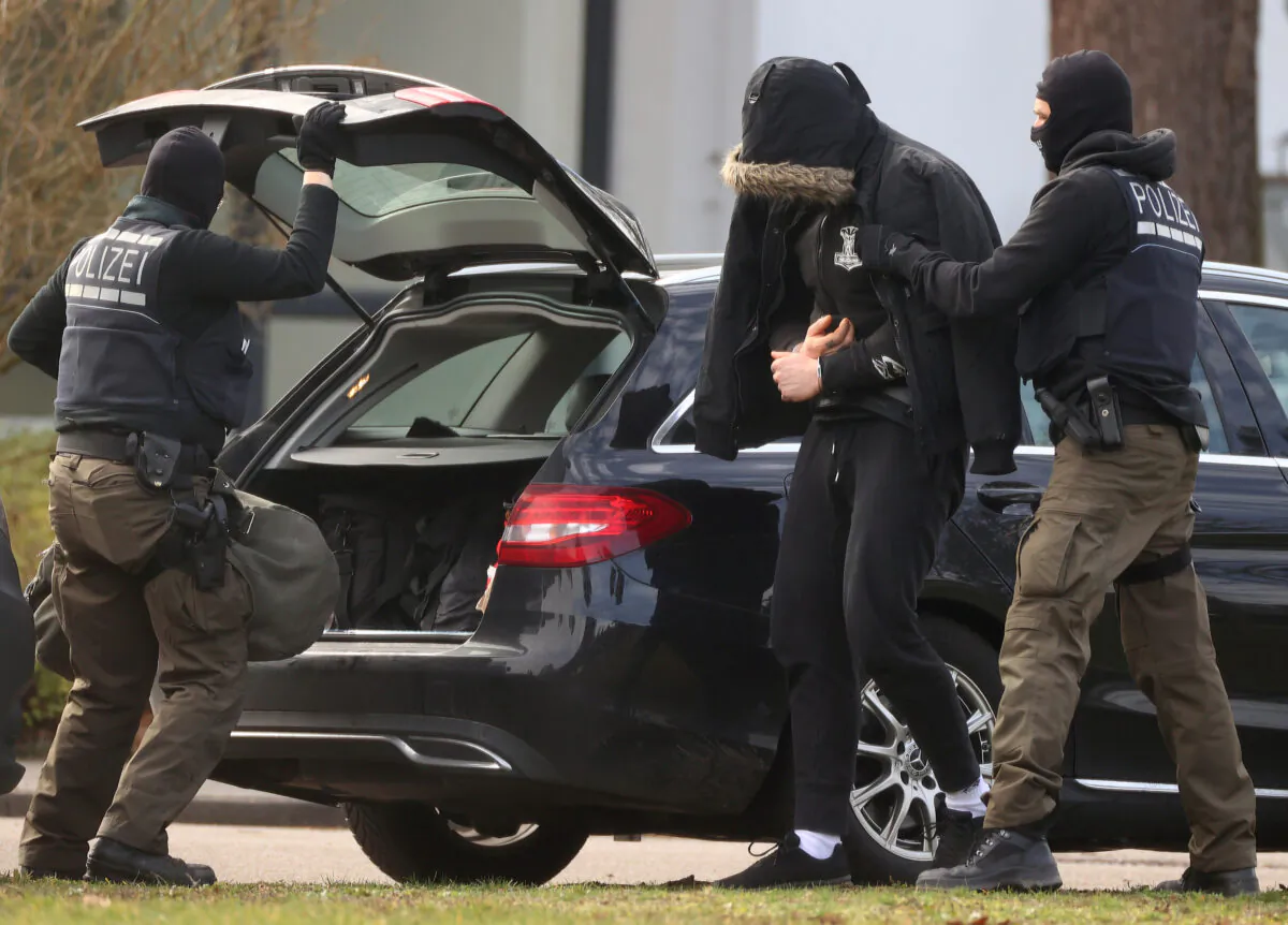 One of 12 men suspected of involvement in a right-wing terrorist group is escorted by police as he arrives for his hearing at Germany's general prosecutor in Karlsruhe, Germany, on Feb. 15, 2020. (Kai Pfaffenbach/Reuters)