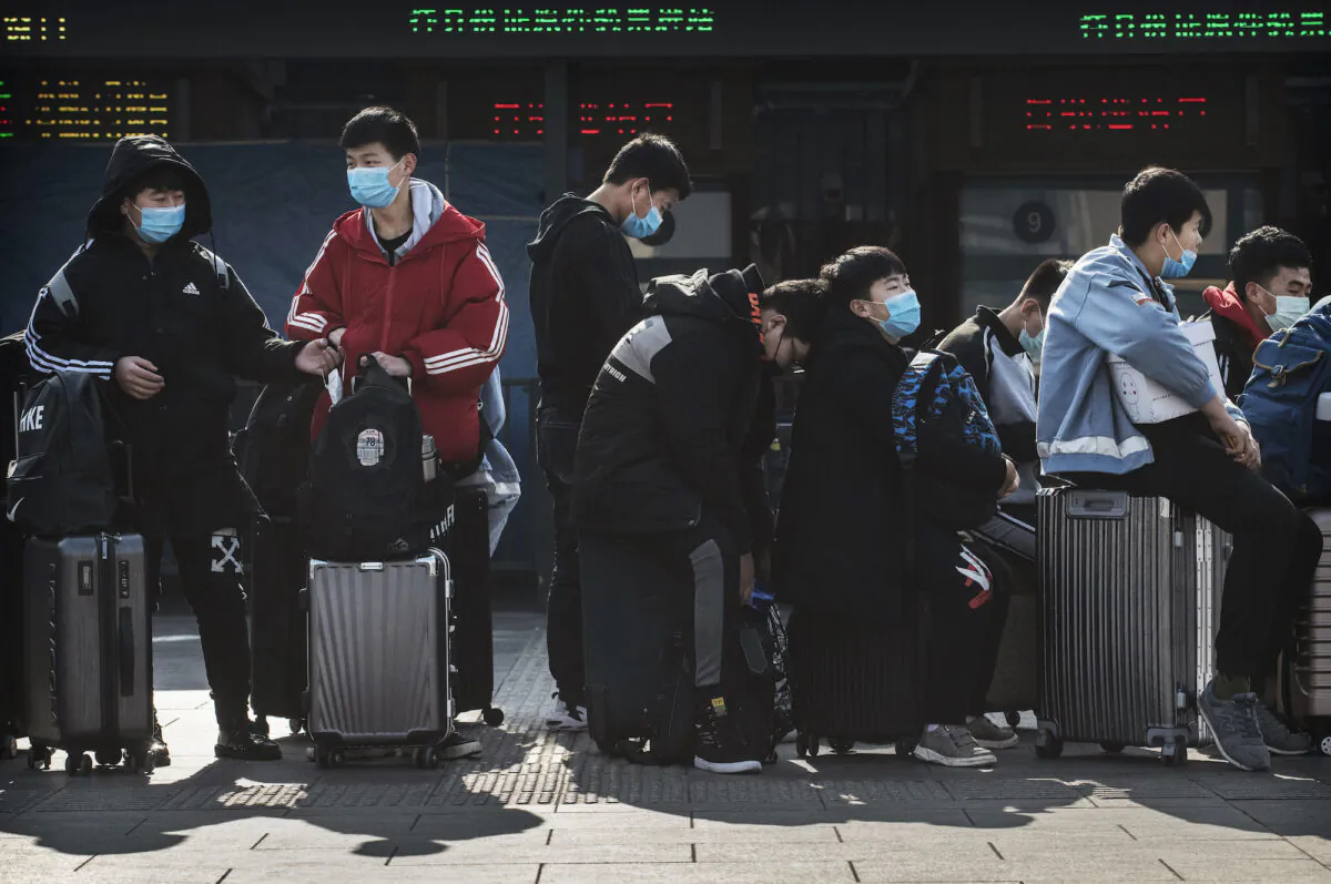 Chinese students wear masks as they wait to take a train after Chinese New Year break in Beijing, China, on Jan. 31, 2020. (Kevin Frayer/Getty Images)