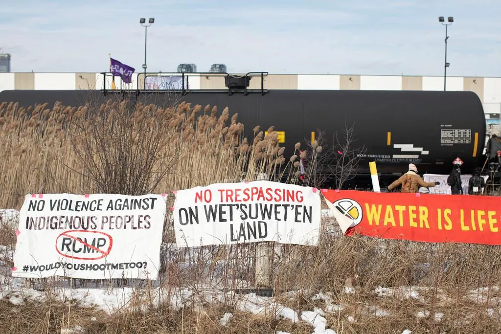 Banners hang on a fence as protesters stage a blockade of the rail line at Macmillan Yard in Toronto, on Feb. 15, 2020. (Chris Young/Canadian press)