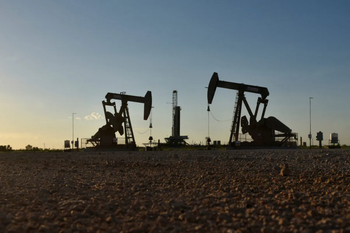 Pump jacks operate in front of a drilling rig in an oil field in Midland, Texas on Aug. 22, 2018. (Nick Oxford/Reuters)